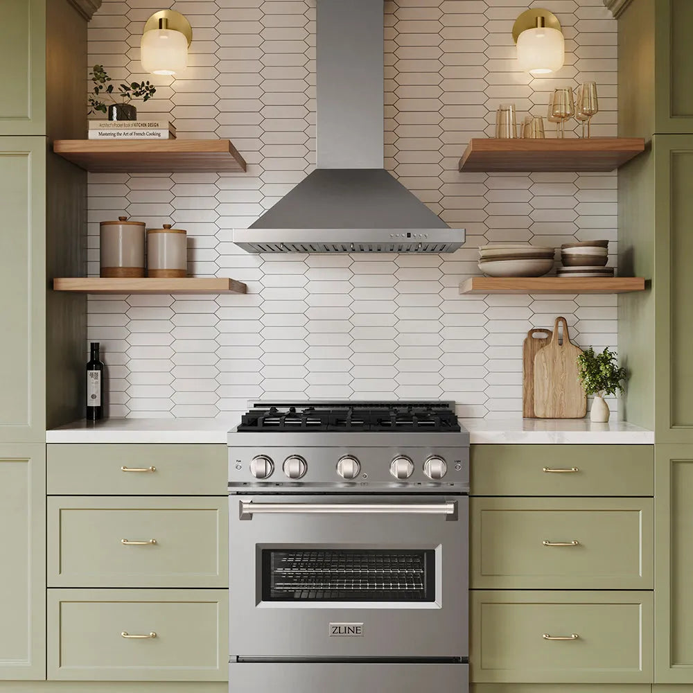 A ZLINE 30 in. Convertible Vent Wall Mount Range Hood in Stainless Steel (KB-30) set in a modern kitchen with sage green cabinets, white hexagonal tile backsplash, and open wooden shelves.
