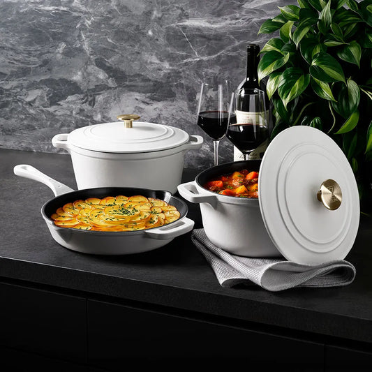 ZLINE 5-Piece Enameled Cast Iron Cookware Set in White Matte (CWSETS-WM-5) on a dark surface with a plant in the background.