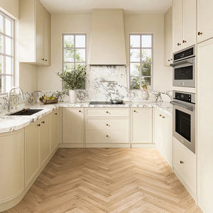 ZLINE 30 in. Induction Cooktop with Anti-Scratch Glass and 4 Elements (FCIND-30) in a modern U-shaped kitchen featuring cream-colored cabinets, white marble countertops and backsplash, light wood herringbone flooring, and stainless steel built-in appliances.