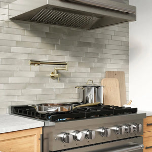 ZLINE 36 in. 5.2 cu. ft. Paramount Gas Range with 6 Burner DuoPro™ Cooktop and Convection Gas Oven in Stainless Steel (PSGR36) with pots and pans on a kitchen counter with tiled backsplash