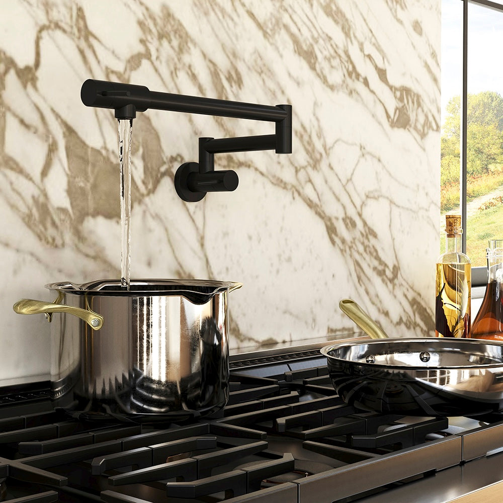 ZLINE Gemini Pot Filler in Matte Black (GEM-FPF-MB) above a stainless steel pot on a gas range against a marble wall.
