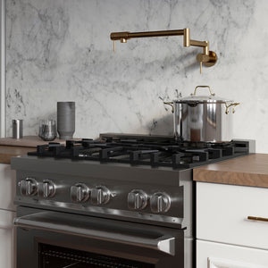 ZLINE Gemini Pot Filler in Polished Gold (GEM-FPF-PG) in a kitchen with a gas range, pots, and a marble backsplash.