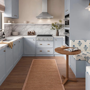ZLINE 30 in. Convertible Vent Wall Mount Range Hood in Stainless Steel (KB-30) in a kitchen with light blue cabinets, a white marble backsplash, wood flooring, a round wooden table, and a built-in patterned bench seat.