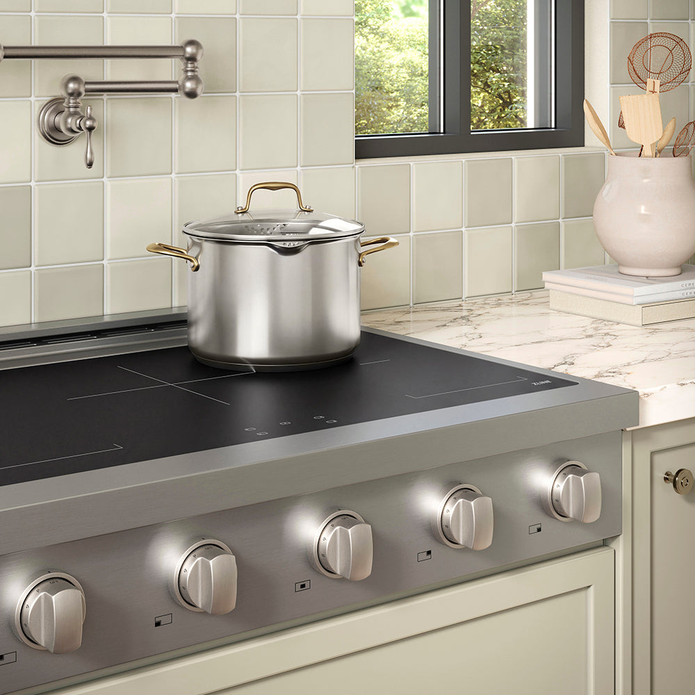 ZLINE 36 in. Paramount Induction Rangetop with 5 Element Cooktop in Stainless Steel (SINRT36) in a designer kitchen with tiled backsplash, light green cabinets, angled.