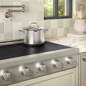 ZLINE 36 in. Paramount Induction Rangetop with 5 Element Cooktop in Satin Stainless Steel (SINRTS-36) in a designer kitchen with tiled backsplash, light green cabinets, angled.