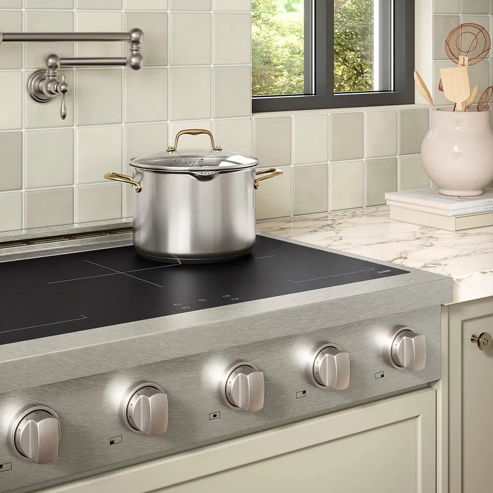 ZLINE 36 in. Paramount Induction Rangetop with 5 Element Cooktop in Satin Stainless Steel (SINRTS-36) in a designer kitchen with tiled backsplash, light green cabinets, angled.