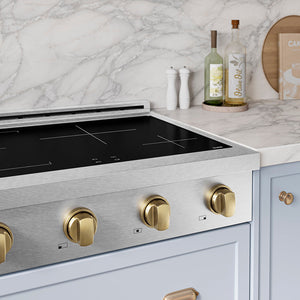 ZLINE Autograph Edition 30 in. Paramount Induction Rangetop with 4 Element Cooktop in Satin Stainless Steel and Champagne Bronze Accents (SINRTSZ-30-CB) in a designer kitchen with marble backsplash, light blue cabinets, angled.