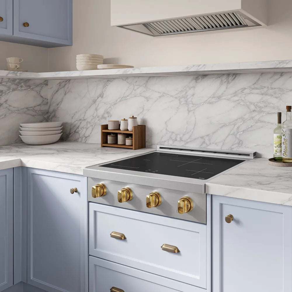 Modern kitchen with marble backsplash, ZLINE Autograph Edition 30 in. Paramount Induction Rangetop with 4 Element Cooktop in Stainless Steel and Polished Gold Accents (SINRTZ-30-G), and light blue cabinets.