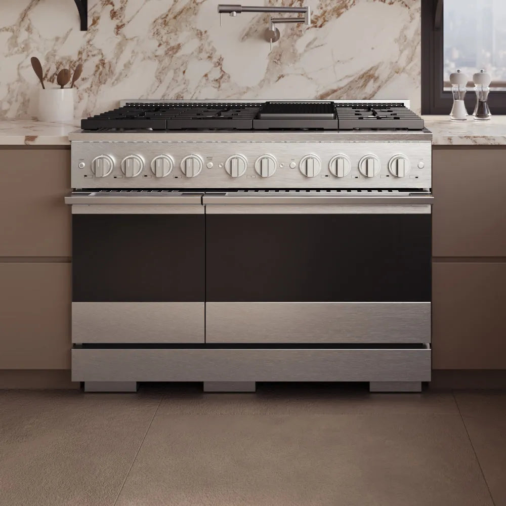 ZLINE 48 in. 6.7 cu. ft. Marino Double Oven Dual Fuel Range in Satin Stainless Steel with 8 Brass Burners (MDRS-BR-48) front, set in a modern kitchen with beige cabinets and a marble backsplash.