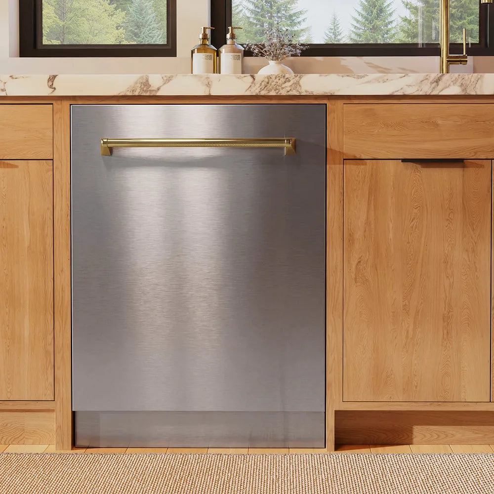 ZLINE Autograph Edition 24 in. Monument Series 3rd Rack Dishwasher with Auto Door Open Drying, 44dBa, Stainless Steel Panel with Polished Gold Handle (DWMTZ-304-24-G) in a kitchen with wooden cabinets and a window view.