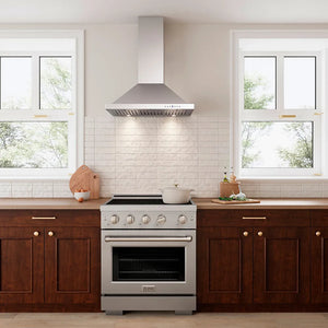 A stainless steel freestanding range with a matching ZLINE 30 in. Convertible Vent Wall Mount Range Hood in Stainless Steel (KB-30), set in a modern kitchen with dark wood cabinets, a white subway tile backsplash, and two windows.