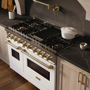 ZLINE Autograph Edition 48 in. 6.7 cu. ft. Classic Gas Range with 8 Burner DuoPro™ Cooktop and Dual Ovens with White Matte Doors and Champagne Bronze Accents (PCGRZ-WM-48-CB) in a custom kitchen with marble backsplash and large range hood, side, above cooktop.
