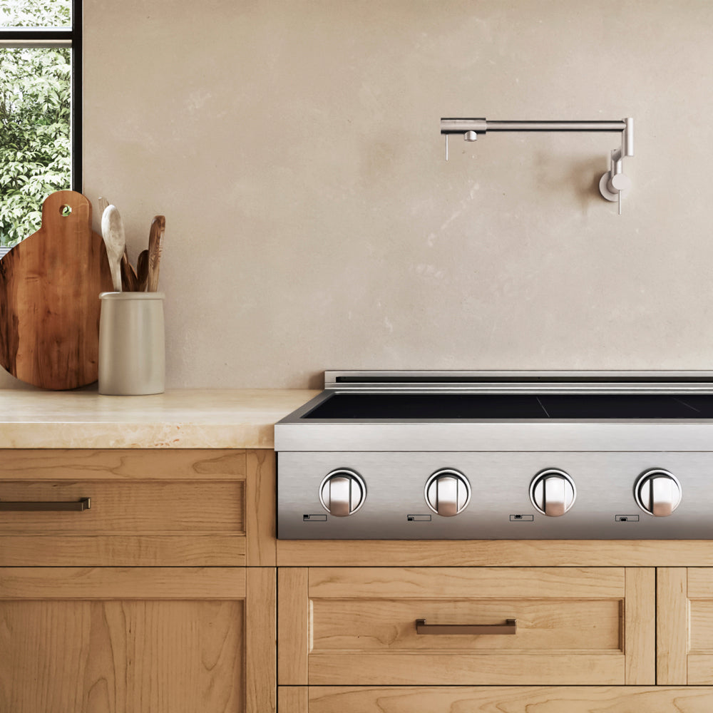 A ZLINE 48 in. Paramount Induction Rangetop with 7 Element Cooktop in Stainless Steel (SINRT48) installed in a light wood kitchen cabinet beneath a beige textured wall and a modern wall-mounted faucet.