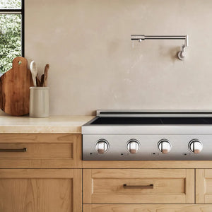 A ZLINE 48 in. Paramount Induction Rangetop with 7 Element Cooktop in Stainless Steel (SINRT48) installed in a light wood kitchen cabinet beneath a beige textured wall and a modern wall-mounted faucet.