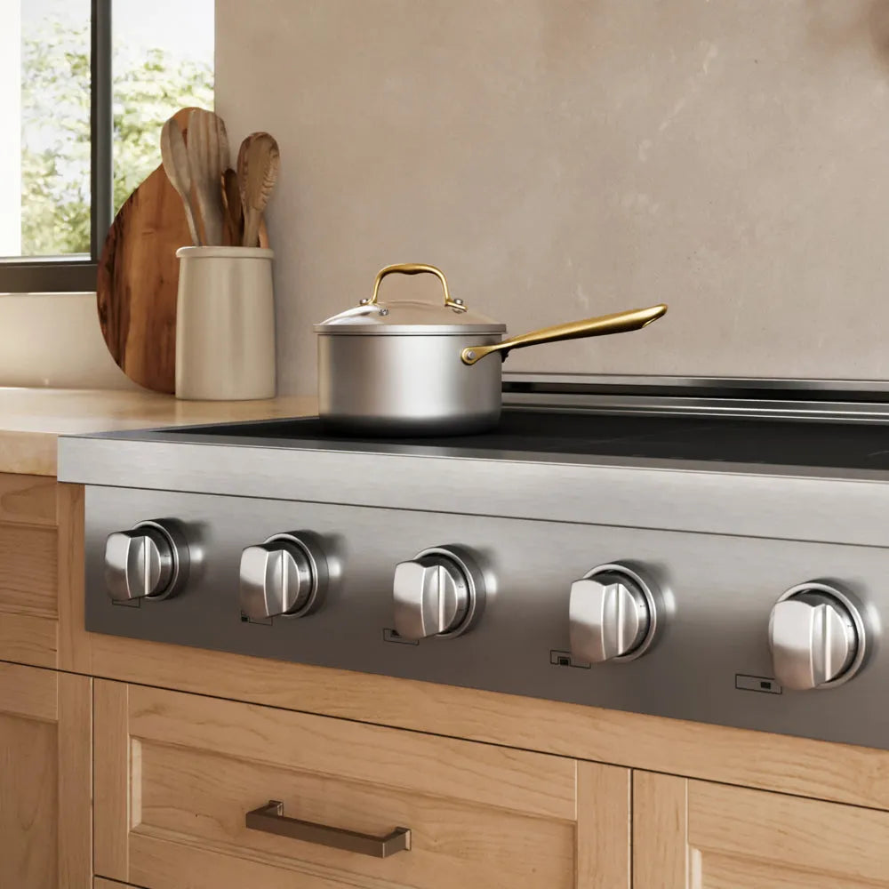 A ZLINE 48 in. Paramount Induction Rangetop with 7 Element Cooktop in Stainless Steel (SINRT48) shown in a modern kitchen setting with a silver pot on the cooktop and light wood cabinetry below.