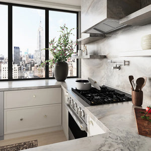 ZLINE 30 in. 4.2 cu. ft. Marino Dual Fuel Range with Gas Cooktop and Electric Convection Oven in Satin Stainless Steel with 4 Brass Burners (MDRS-BR-30) side, set in a modern kitchen with white cabinetry, marble countertops, a large window overlooking a city skyline, and a potted plant on the counter.