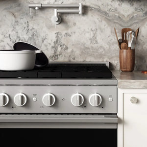 ZLINE 30 in. 4.2 cu. ft. Marino Gas Range with 4 Burner Cooktop and Convection Gas Oven in Stainless Steel (MGR30) front close-up, set in a modern kitchen with marble countertops. A white pot sits on the cooktop, and a wooden utensil holder is on the counter.
