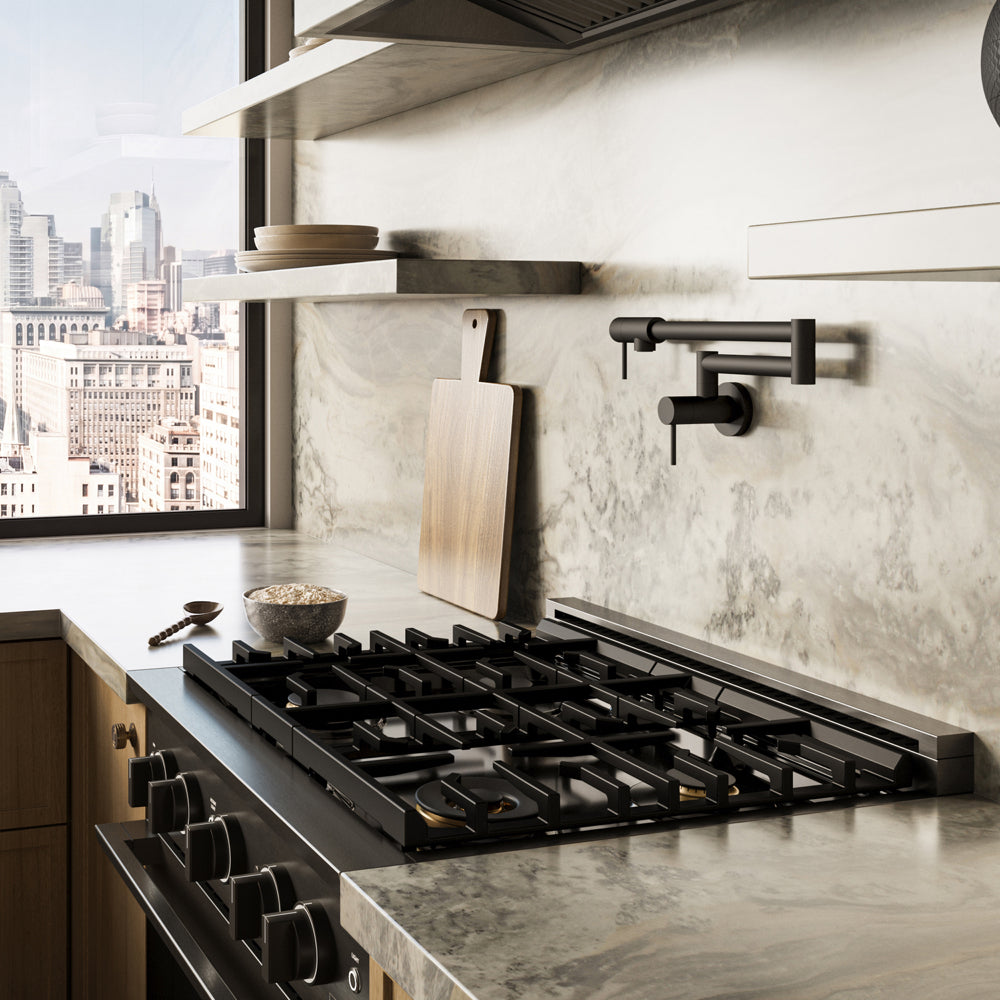 ZLINE 30 in. 4.2 cu. ft. Marino Dual Fuel Range with Gas Cooktop and Electric Convection Oven in Black Stainless Steel with 4 Brass Burners (MDRB-BR-30) side, in a modern kitchen set into a light gray stone countertop and backsplash, with a window showing a city skyline in the background.