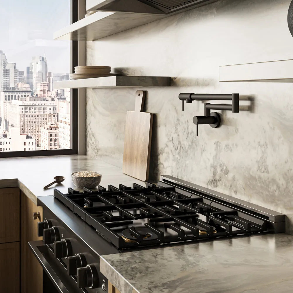 ZLINE 30 in. 4.2 cu. ft. Marino Dual Fuel Range with Gas Cooktop and Electric Convection Oven in Black Stainless Steel with 4 Brass Burners (MDRB-BR-30) side, in a modern kitchen set into a light gray stone countertop and backsplash, with a window showing a city skyline in the background.