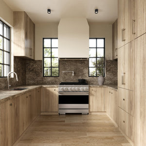 ZLINE 36 in. 5.2 cu. ft. Marino Dual Fuel Range with 6 Burner Gas Cooktop and Electric Convection Oven in Satin Stainless Steel (MDRS-36) front, set in a modern kitchen with light wood cabinets, a textured stone backsplash, and a black pot on the cooktop.