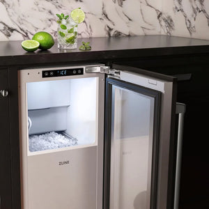 ZLINE 15 in. Touchstone Nugget Ice Maker with Drain Pump and Panel-Ready Door (INGDP-15), shown open with ice inside installed in a cabinet beneath a black countertop with a marble backsplash.