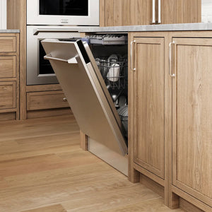 A built-in ZLINE 24 in. Tallac Series 3rd Rack Dishwasher with Auto Door Open Drying, 51dBa, Stainless Steel Panel (DWV-304-24) with its door open, showing the interior racks and dishes, installed in a modern kitchen with light oak wood cabinets and a wood-look floor.