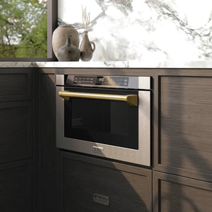 ZLINE Autograph Edition 24 in. 1.2 cu. ft. Built-in Microwave Drawer with a Traditional Handle in Stainless Steel and Champagne Bronze Accents (MWDZ-1-H-CB) embedded in wooden kitchen cabinets with a window view.