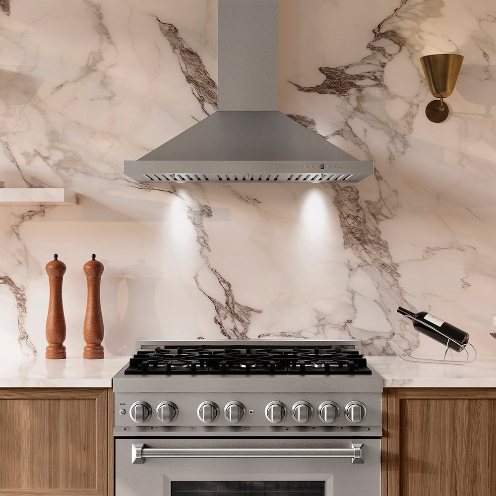 Modern kitchen with ZLINE 36 in. Convertible Vent Wall Mount Range Hood in Stainless Steel (KB-36) and stove against a marble backsplash.