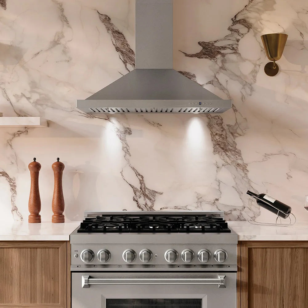 Modern kitchen with ZLINE 36 in. Convertible Vent Wall Mount Range Hood in Stainless Steel (KB-36) and stove against a marble backsplash.