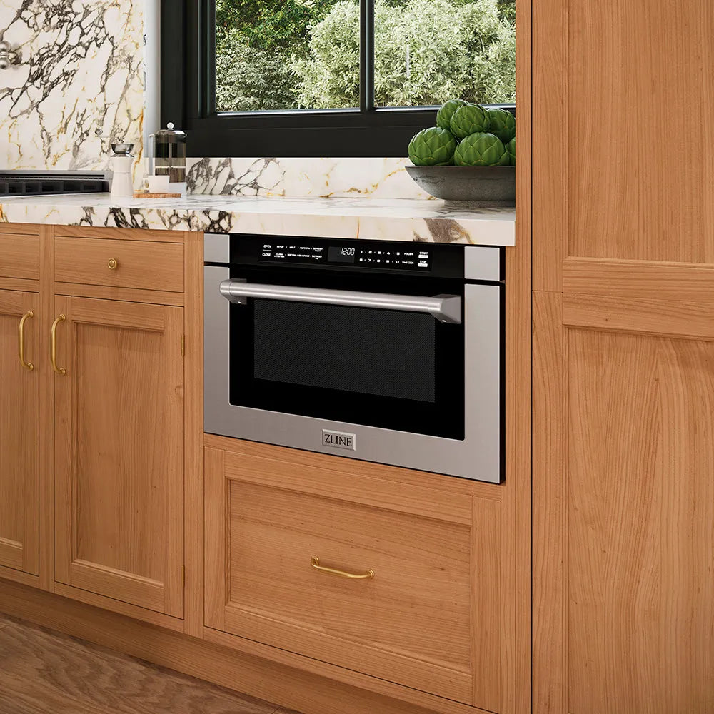 ZLINE 24 in. 1.2 cu. ft. Built-in Microwave Drawer with a Traditional Handle in Stainless Steel (MWD-1-H) embedded in wooden kitchen cabinetry with a window in the background.