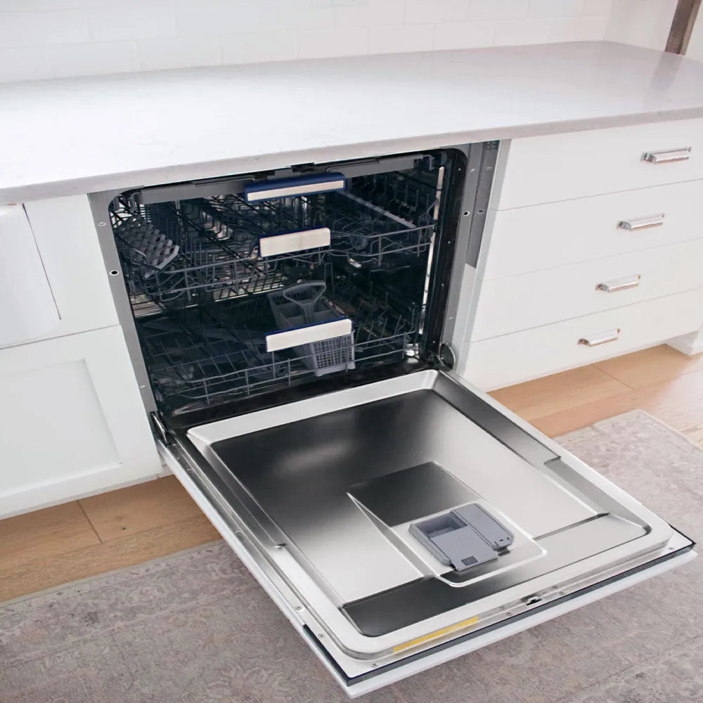 ZLINE Autograph Edition 24 in. Tallac Series 3rd Rack Dishwasher with Auto Door Open Drying, 51dBa, Panel Ready with Matte Black Handle (DWVZ-24-MB) open in a kitchen setting with white cabinets and wooden floor.