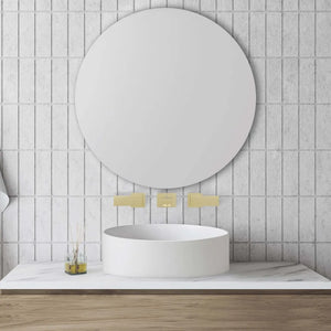 ZLINE Autograph Edition Bliss Wall Mount Bath Faucet in Polished Gold (BLS-BFW-PG) in a bathroom with a round mirror, sink, and towels on a tiled wall.