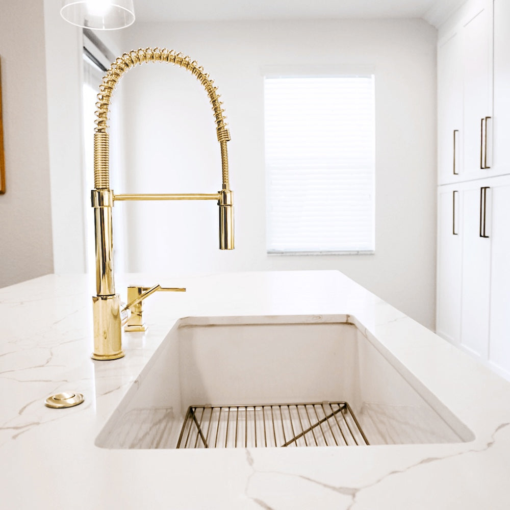 ZLINE Sierra Pull Down Spring Single Handle Kitchen Faucet in Polished Gold (SRA-KF-PG) in a white kitchen setting