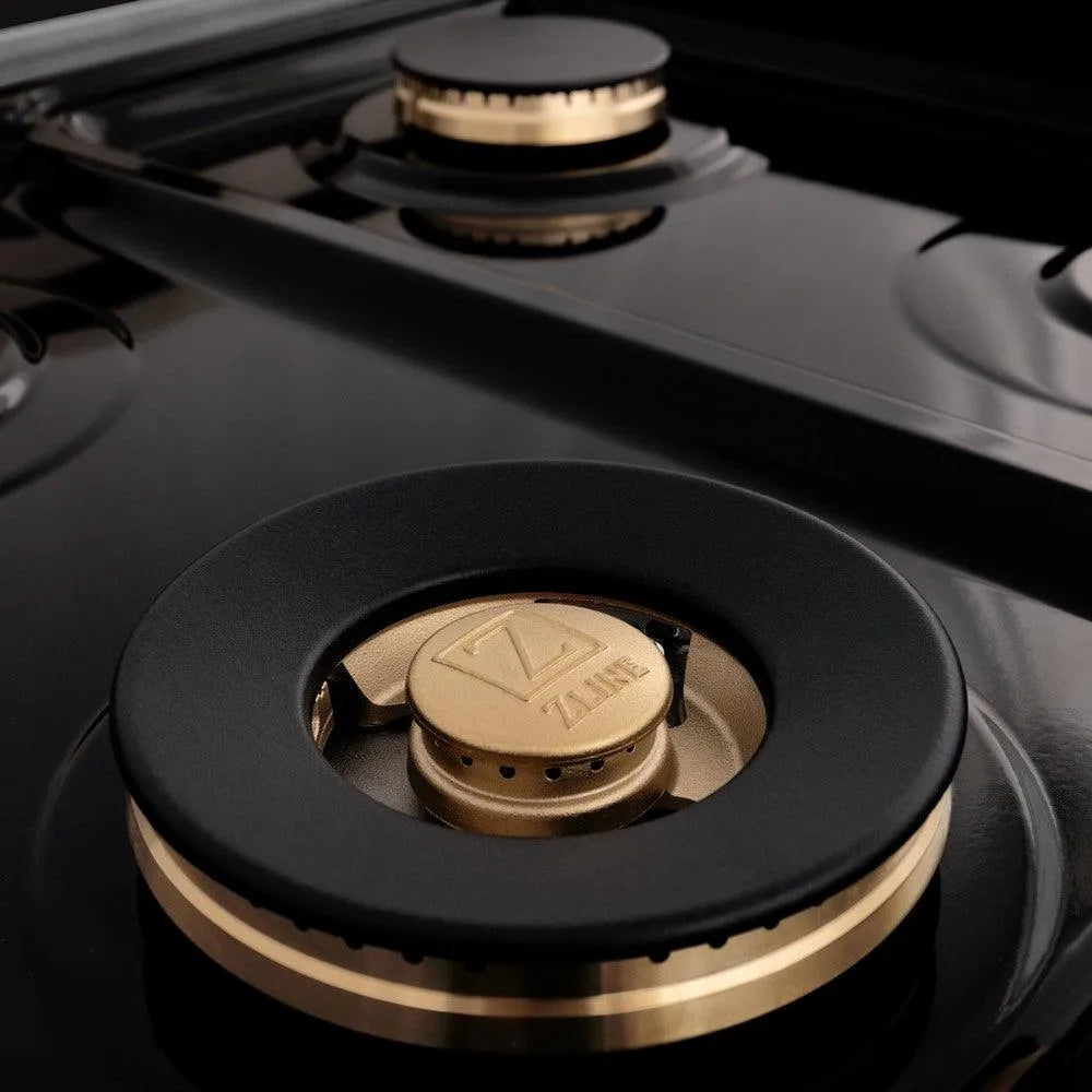 ZLINE Autograph Edition 60 in. 7.4 cu. ft. Legacy Dual Fuel Range with 9 Burner Gas Cooktop and 2 Electric Convection Ovens in Stainless Steel with White Matte Doors and Champagne Bronze Accents (RAZ-WM-60-CB) brass burner and black porcelain cooktop.