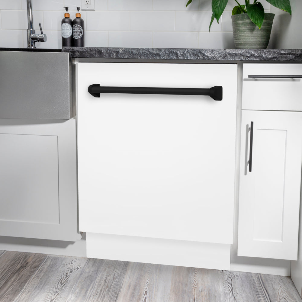 ZLINE Autograph Edition 24 in. Tallac Series 3rd Rack Dishwasher with Auto Door Open Drying, 51dBa, White Matte Panel with Matte Black Handle (DWVZ-WM-24-MB) in a modern kitchen with white cabinets and a gray countertop.
