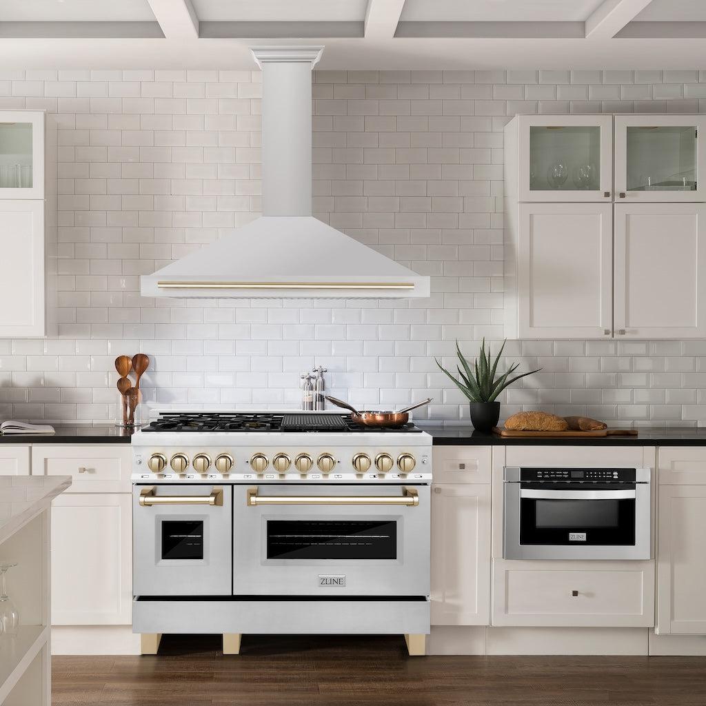 ZLINE Autograph Edition Convertible Stainless Steel Range Hood with Stainless Steel Shell and Polished Gold Accents (KB4STZ-G) in a luxury kitchen with matching range and microwave.