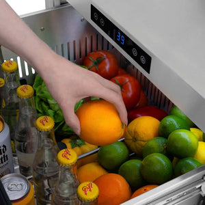 Hand reaching into a ZLINE 24 in. Touchstone 168 Can Outdoor-Rated Dual Refrigerator Drawer with Hand Hammered Copper Doors (RDSO-HH-24)  filled with fruits and drinks, with a digital display showing 39 degrees.