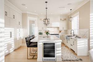 Modern kitchen with white cabinets, island, and ZLINE Autograph Edition 24 in. Monument 154 Can Beverage Fridge in Stainless Steel with Champagne Bronze Accents (RBVZ-US-24-CB)