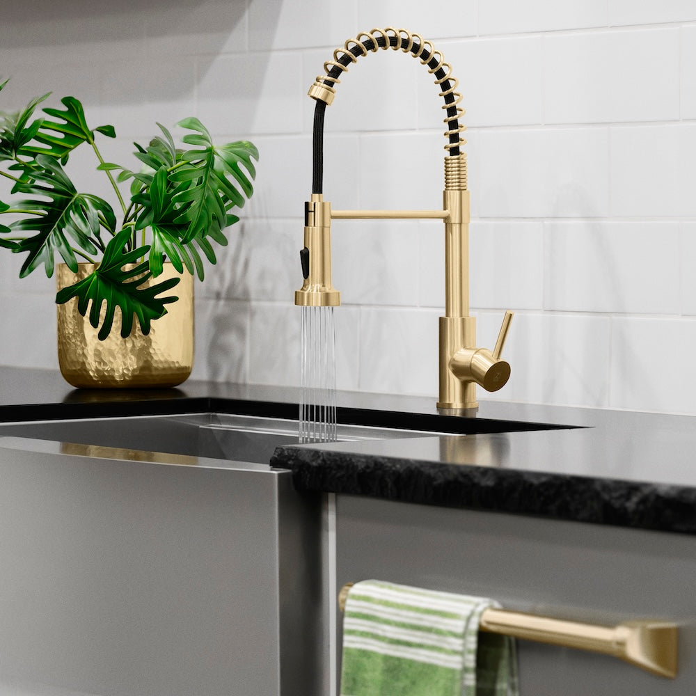 ZLINE Palisades Pull Down Spring Spray Wand Kitchen Faucet in Champagne Bronze (RBCN2-KF-CB) in a luxury kitchen, water on.