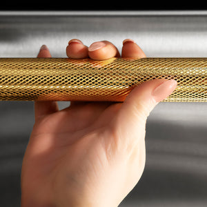 ZLINE Autograph Edition 24 in. Monument Series 3rd Rack Top Touch Control Tall Tub Dishwasher in Stainless Steel with Polished Gold Helix Handle, 45dBa (DWMTZ-30424-KG) hand holding Helix handle showing knurled diamond texture.