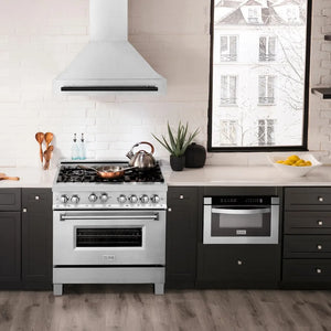Modern kitchen with ZLINE Autograph Edition 36 in. Satin Stainless Steel Wall Mount Range Hood with Matte Black Handle (8654SNZ-36-MB), stainless steel range, black cabinets, and white countertops.
