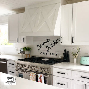 Cottage-style kitchen with white cabinets, stainless steel range, decorative backsplash, and a custom tapered range hood using a ZLINE 46 in. Ducted Wall Mount Range Hood Insert in Stainless Steel (698-46).