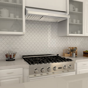 ZLINE 36 in. Ducted Under Cabinet Range Hood in Stainless Steel (623-36) above a stainless steel gas cooktop in a farmhouse kitchen with white cabinets and backsplash.