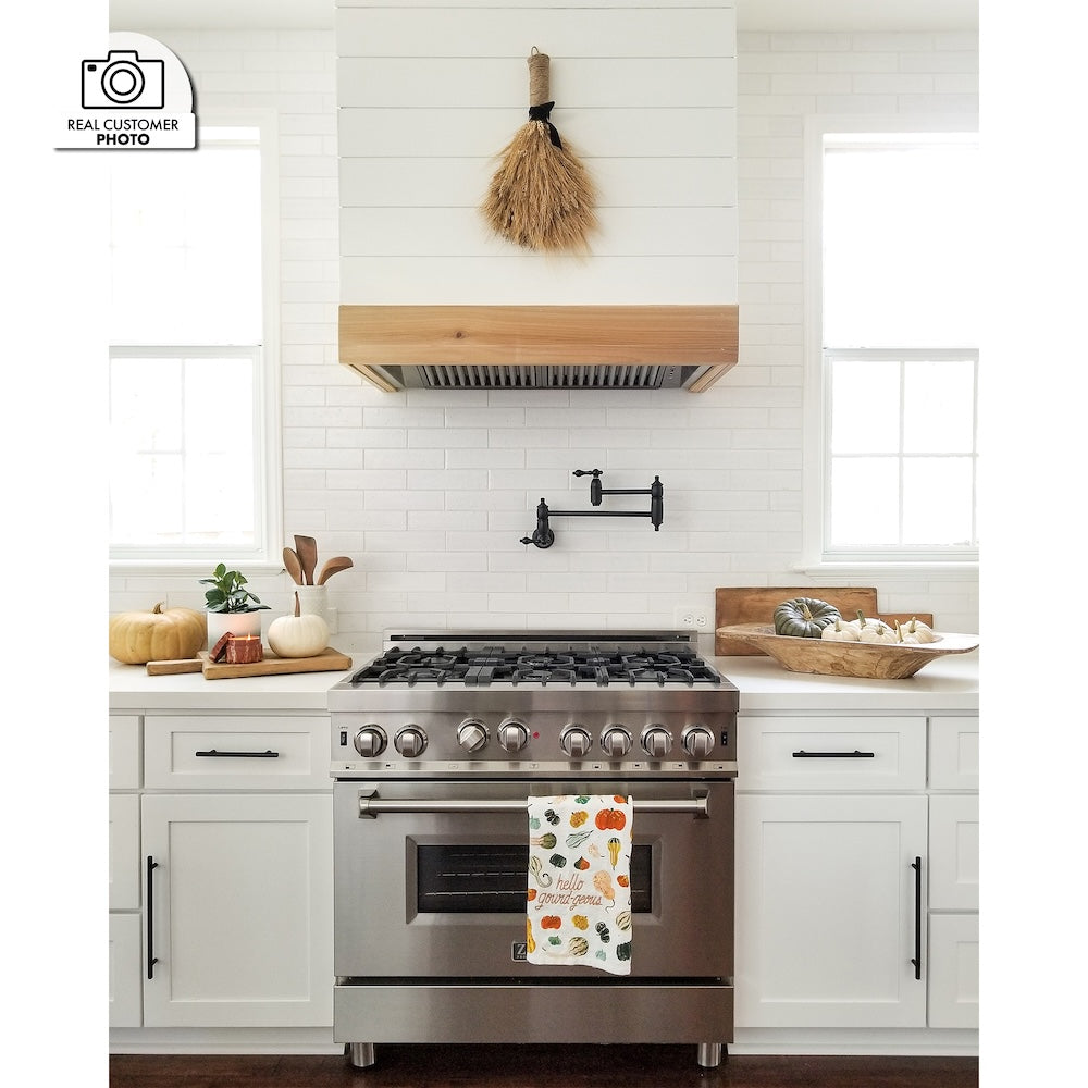 Farmhouse kitchen with stainless steel range, white cabinets, decorative elements, and a custom shiplap range hood using aZLINE 46 in. Ducted Wall Mount Range Hood Insert in Stainless Steel (698-46).