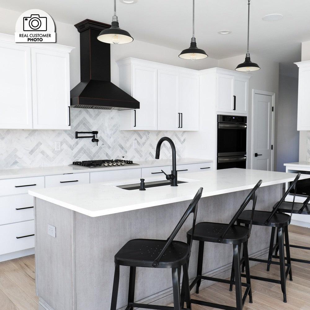 ZLINE Designer Series Wall Mount Range Hood in Oil-Rubbed Bronze (8667B) in a white cottage-style kitchen.