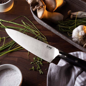 ZLINE German steel chef knife on cutting board with chopped vegetables