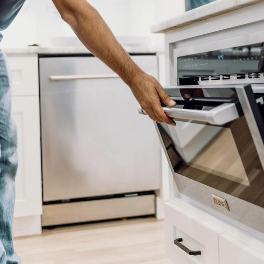 ZLINE 24 in. Built-in Convection Microwave Oven in Fingerprint Resistant Stainless Steel (MWO-24-SS) Lifestyle image of a man opening the microwave door in a luxury kitchen.