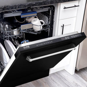 ZLINE 24 in. Tallac Series 3rd Rack Dishwasher with Black Matte Panel and Traditional Handle, 51dBa (DWV-BLM-24) half open with dishes inside in a kitchen with white cabinets and stone countertops.