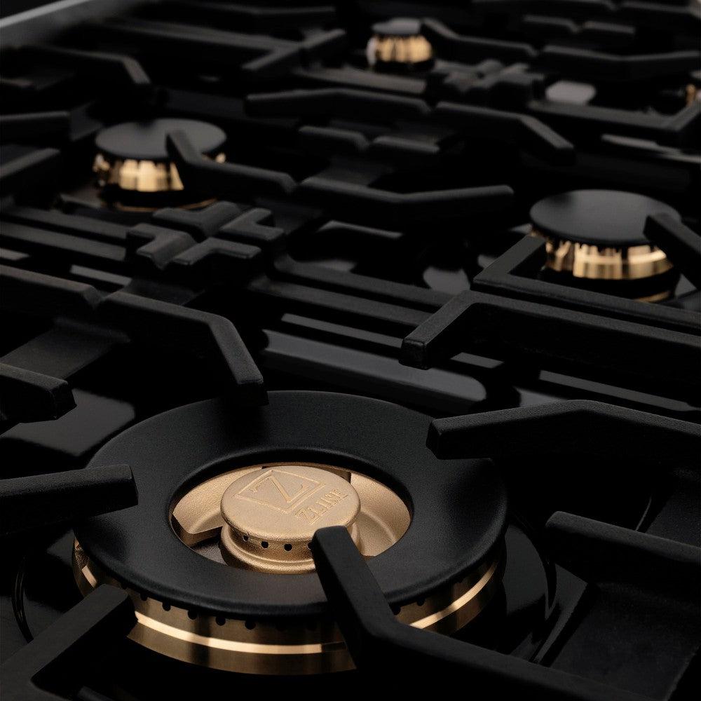 ZLINE brass burners on black porcelain cooktop with cast-iron grates.