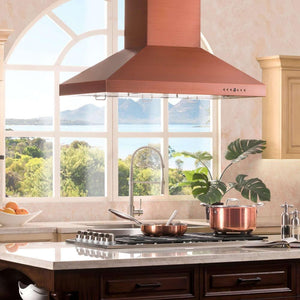 ZLINE 36 in. Designer Series Copper Island Mount Range Hood (8KL3iC-36) above a large kitchen island in a rustic kitchen.